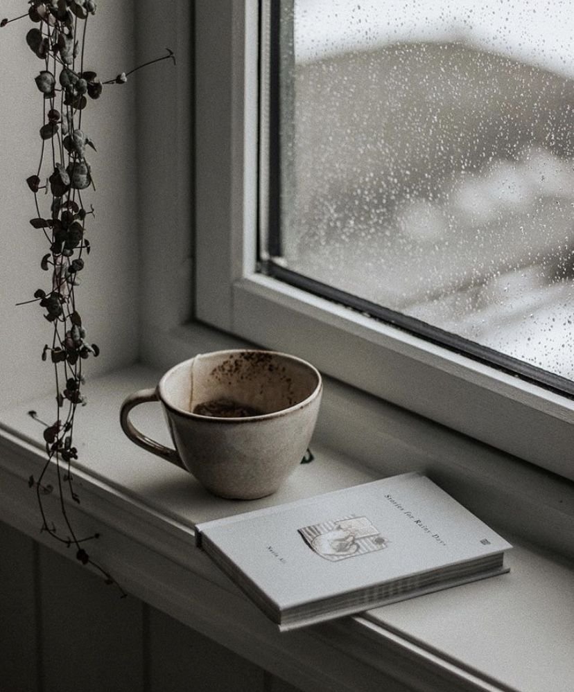 Taza de cerámica junto a una ventana con lluvia — psicóloga online para el duelo
